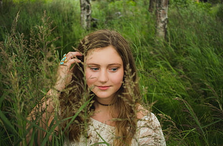 woman wearing white scoop-neck top in grass during daytime thumbnail