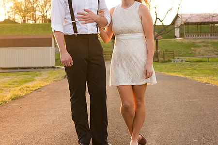couple holding hands while walking on concrete pavement at daytime thumbnail