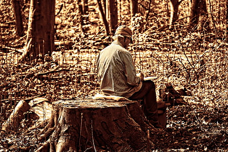 man sitting on round wooden surface thumbnail
