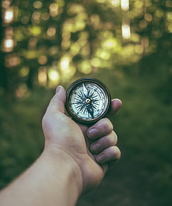 person holding gray and white compass thumbnail