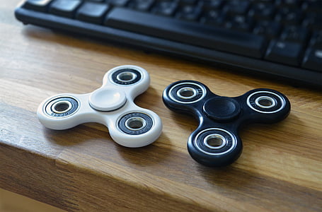 two fidget spinners on desk near keyboard thumbnail