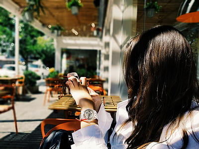 woman sitting on chair holding Android smartphone thumbnail