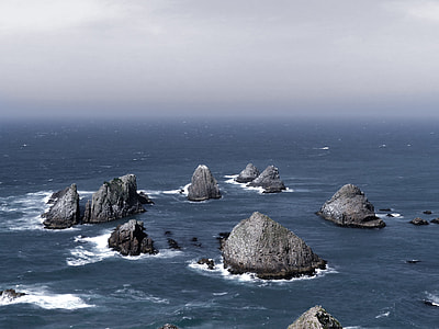 aerial photography of gray rock formations on body of water thumbnail