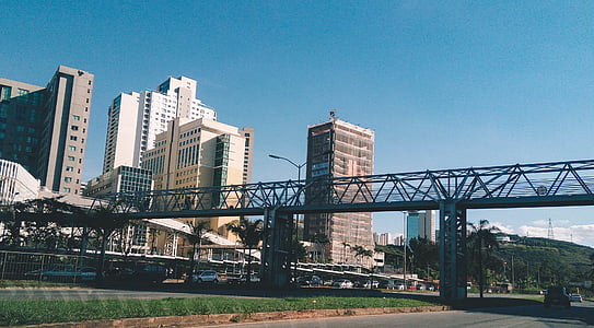 bridge near high rise buildings under blue sky thumbnail