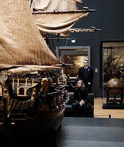 woman sitting on black couch behind galleon ship table decor thumbnail