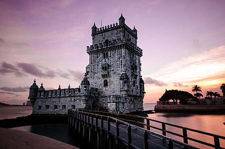 brown castle beside body of water at sunset thumbnail