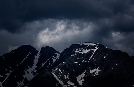 photography of snow coated mountains under nimbus clouds thumbnail
