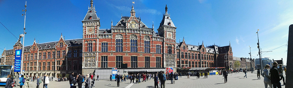 people standing near brown and grey concrete building under blue sky thumbnail
