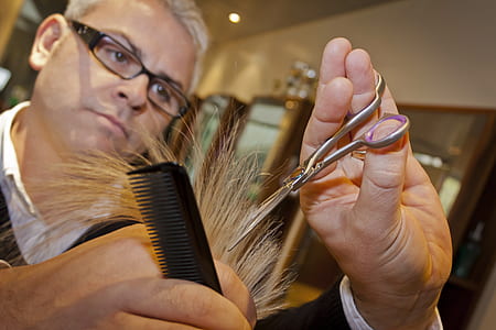man trimming hair using scissors and comb thumbnail