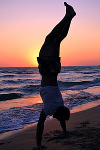 man standing on hands near seashore thumbnail