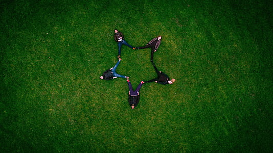 five people laying on green landscape photgraphy thumbnail