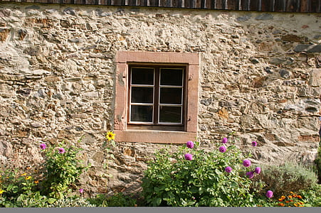 brown and beige stone wall with glass pane window thumbnail