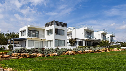 white concrete house surrounded with green plants thumbnail