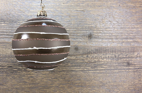 brown and white striped bauble on brown wooden surface thumbnail