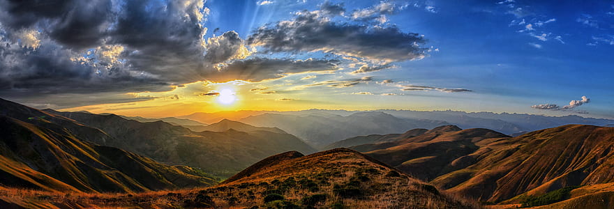 aerial photography of brown mountains under cloudy sky thumbnail