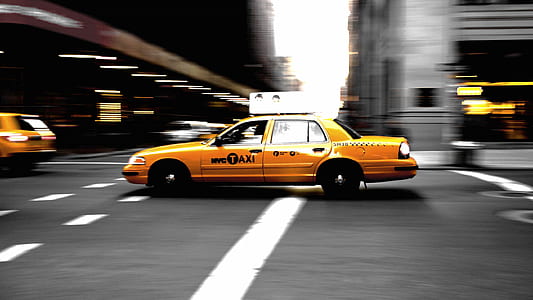 panning photography of yellow taxi on street thumbnail