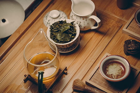 White Ceramic Teapot Beside Cup With Leaves thumbnail