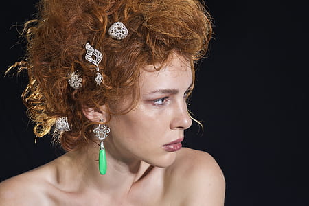 woman facing to her left in black background thumbnail