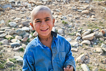 boy in blue dress shirt near stones thumbnail