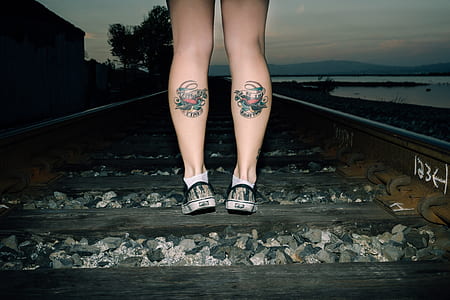 person standing on train rail during daytime thumbnail
