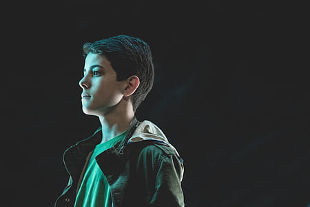 boy standing side-way while wearing black button-up jacket thumbnail