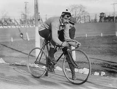 grayscale photo of a man riding a bicycle thumbnail