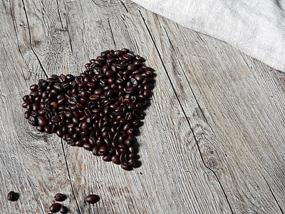 coffee beans formed into heart on gray surface thumbnail