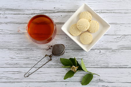 round white pastried on square plate beside red liquid filled clear glass cup and green plant thumbnail