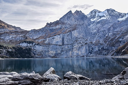 landscape photography of body of water with mountains thumbnail