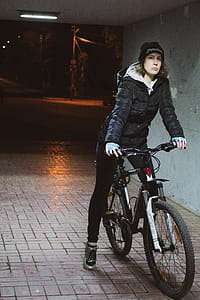 Woman Wearing Black Coat Riding on Her Bicycle thumbnail