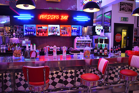 Freddy's Bar with neon lights turned on and red stools thumbnail