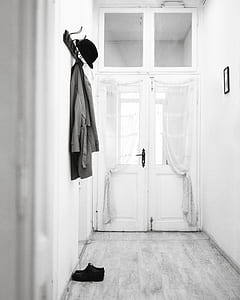 grascale photography of coat and hat handed on the wall at the corridor thumbnail