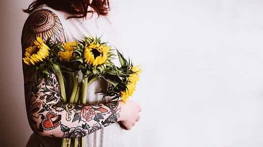 person holding four yellow flowers thumbnail