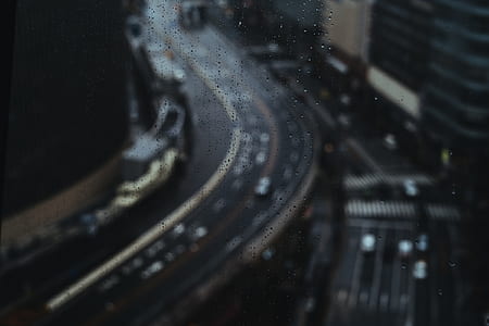 bokeh photography of curved road with cars at rainy daytime thumbnail