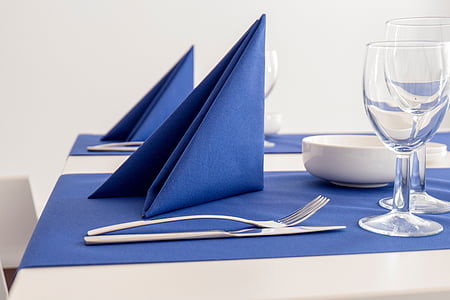 blue table napkin near silver fork and knife on top of blue textile thumbnail