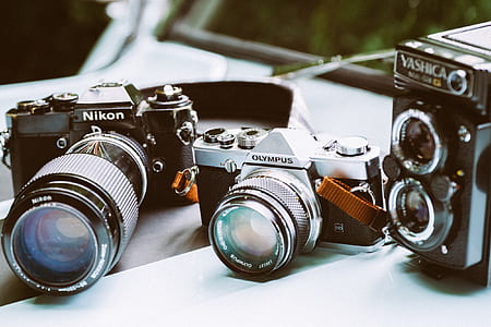 three assorted cameras on white surface thumbnail