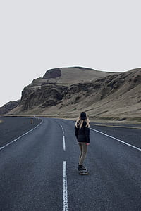 woman in black jacket skateboarding on gray road thumbnail