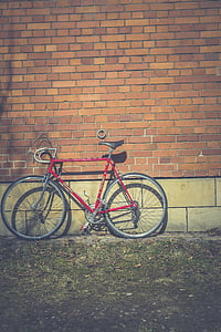 red road bike leaning on wall at daytime thumbnail