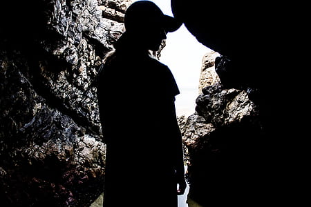 silhouette photography of person inside a cave during daytime thumbnail