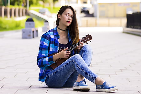 woman sitting on ground while playing ukulele thumbnail