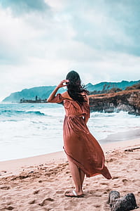 woman standing on beige sand near seashore thumbnail