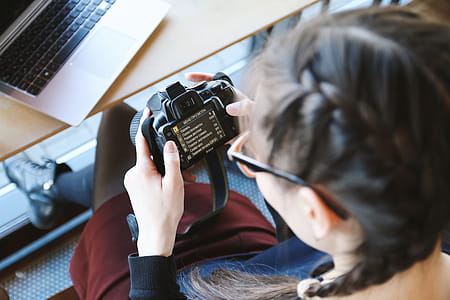 Young girl check her DSLR camera at cafe thumbnail