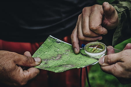 person holding green map and compass thumbnail