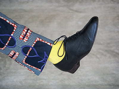 person wearing unpaired black dress shoe thumbnail