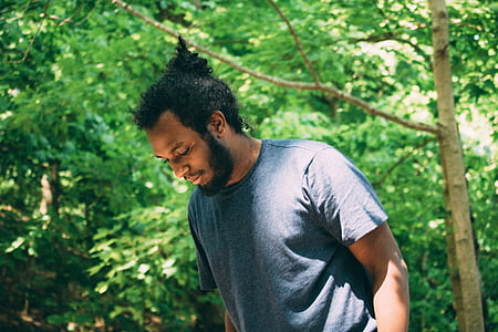 man wearing black crew-neck shirt near trees thumbnail