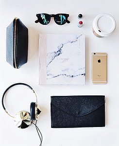 black sunglasses and gold iPhone 6 on white surface thumbnail