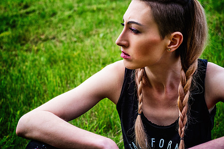 woman sitting on grass during daytime thumbnail