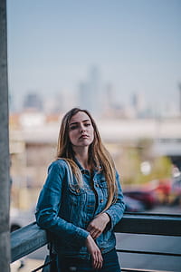 woman standing near gray concrete grille during daytime photo thumbnail
