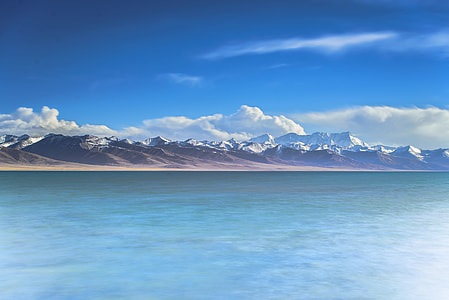 landscape photography of body of water under cloudy sky thumbnail