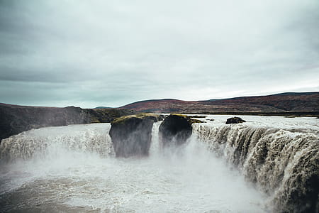Rapids forming waterfall by a river becoming shallower in the mountains in Iceland thumbnail
